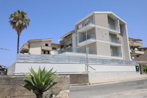 a building with a palm tree in front of it at Il Narciso Residence in Tropea