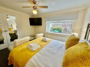 a bedroom with a large bed with a yellow blanket at Pass the Keys A BeachhouseHome away from Home in Clacton-on-Sea