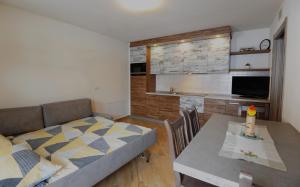 uma sala de estar com um sofá, uma mesa e uma cozinha em Casa Fiocco Di Neve em Livigno