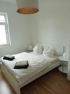 a white bed with two towels on top of it at Stadtgrün 1 in Berlin