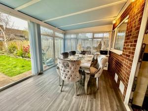 a screened in porch with a table and chairs at Pass the Keys A BeachhouseHome away from Home in Clacton-on-Sea