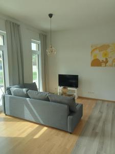 a living room with a couch and a television at Stadtgrün 1 in Berlin