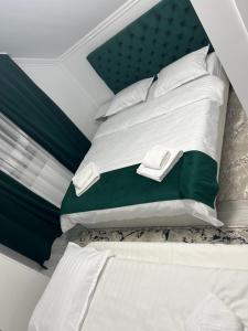 een slaapkamer met een bed met wit en groen bij Vila PauDeea in Moisei