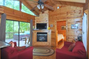 a living room with a fireplace in a log cabin at Sleepy Creek - Creekside Escape in Berkeley Springs