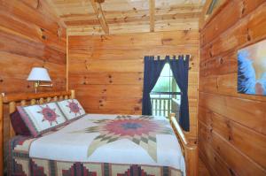 a bedroom with a bed in a log cabin at Sleepy Creek - Creekside Escape in Berkeley Springs