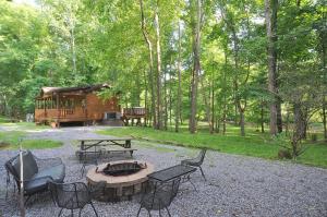 a cabin with a table and chairs and a fire pit at Sleepy Creek - Creekside Escape in Berkeley Springs