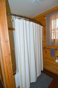 uma casa de banho com uma cortina de chuveiro branca num quarto em Seventh Heaven - Heavenly Retreat em Great Cacapon