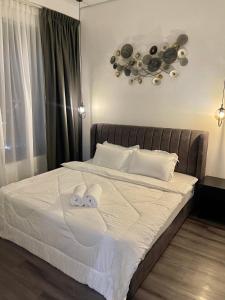ein Schlafzimmer mit einem Bett mit zwei Handtüchern darauf in der Unterkunft SINA Troika Residence Kota Bharu 1BR Netflix Pool in Kota Bharu