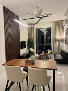 ein Wohnzimmer mit einem Holztisch und Stühlen in der Unterkunft SINA Troika Residence Kota Bharu 1BR Netflix Pool in Kota Bharu