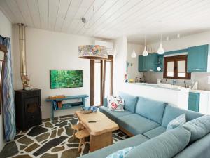 sala de estar con sofá azul y mesa en Dendrinos House, en Galissas