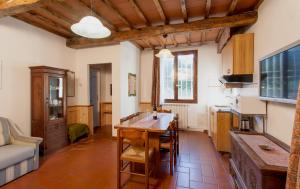 グレーヴェ・イン・キアンティにあるVilla Buonasera Agriturismoのテーブルと椅子のあるキッチンとリビングルーム