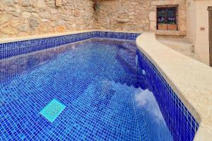 ein großer Pool mit blauen Fliesen in einem Gebäude in der Unterkunft Ferienhaus mit Privatpool für 6 Personen ca 100 m in S'Horta, Mallorca Südostküste von Mallorca in S'Horta