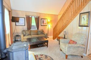 Trails End River Retreat - River Access - Pet Friendly - Hot Tub - Grill - Wifi - Fire Pit - Deck - Screen Porch - Family Friendly - Fishing - King Bed - Wood Stove في بيركلي سبرينغز: غرفة معيشة بها أريكة وطاولة