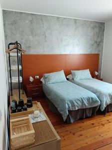 um quarto com 2 camas e piso em madeira em Affittacamere La Loggia em Venzone