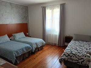 um quarto com 2 camas e uma janela em Affittacamere La Loggia em Venzone