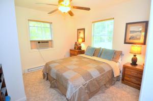 Trails End River Retreat - River Access - Pet Friendly - Hot Tub - Grill - Wifi - Fire Pit - Deck - Screen Porch - Family Friendly - Fishing - King Bed - Wood Stove في بيركلي سبرينغز: غرفة نوم بها سرير ومروحة سقف