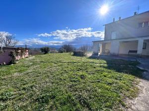 une cour avec une maison et le soleil dans le ciel dans l'établissement Residence San Martino, à Busso
