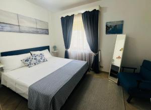 a bedroom with a bed and a blue chair at Casa La Radio in Anacapri