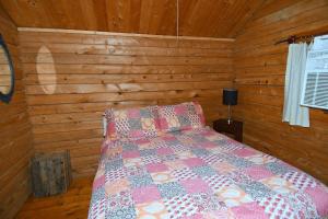 a bedroom with a bed in a wooden room at Whispering Hills - Couples Getaway in Hedgesville