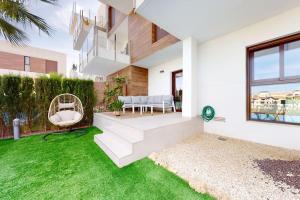 een tuin met een wit huis met een gazon bij Apartmán s vlastním bazénem in Orihuela