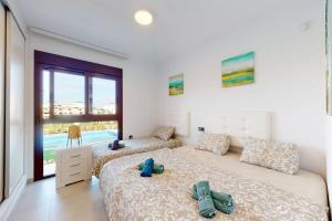 een slaapkamer met twee bedden met handdoeken erop bij Apartmán s vlastním bazénem in Orihuela +12 foto's