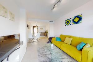 een woonkamer met een gele bank en een keuken bij Apartmán s vlastním bazénem in Orihuela