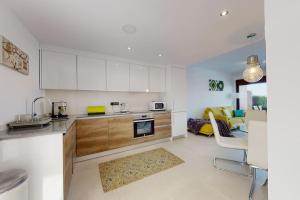 een keuken met witte kasten en een woonkamer bij Apartmán s vlastním bazénem in Orihuela