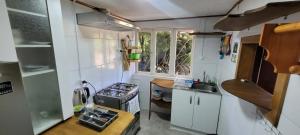 a small kitchen with a stove and a window at Cabañas Buen Recuerdo in Puyehue