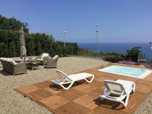 eine Terrasse mit 2 Stühlen und einem Pool in der Unterkunft Cyclopes House Amazing view and Private Mini Spa in Aci Catena