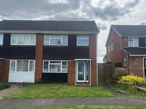 a red brick house with a white door at 3-Bed House - Sleeps 5 with free on street parking in Leighton Buzzard