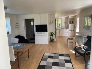 a living room with a table and a kitchen at Marielyst Beach and downtown rooms in Bøtø By