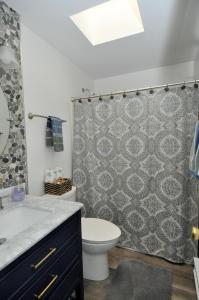 a bathroom with a toilet and a shower curtain at Herons Rest - Escape by the River in Great Cacapon