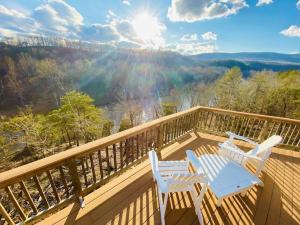 two chairs and a table on a deck with a view at River View Cabin - Mountain Views in Morton Grove