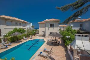 einen Pool mit Stühlen und Sonnenschirmen neben einem Haus in der Unterkunft Ferienhaus für 9 Personen ca 190 qm in Protaras, Südküste von Zypern in Protaras