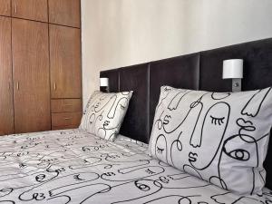 a bedroom with a black and white bed with pillows at TEO Apartment in Paphos +34 photos