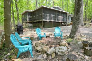 a house with blue chairs around a fire pit at Bear Necessities -Forget your Worries! in Great Cacapon