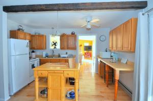 a kitchen with wooden cabinets and a white refrigerator at Bear Necessities -Forget your Worries! in Great Cacapon