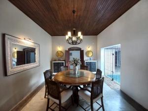 a dining room with a table and chairs and a mirror at Whispering Palms Retreat 