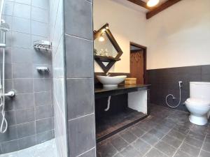 a bathroom with a sink and a toilet at Whispering Palms Retreat 