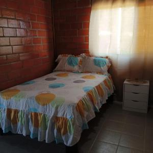 a bed in a room with a brick wall at PLAYA DEL REY in Carrizal