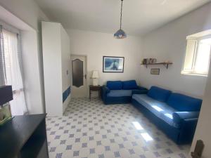 uma sala de estar com um sofá azul e uma mesa em Casina Edomilla em Capri