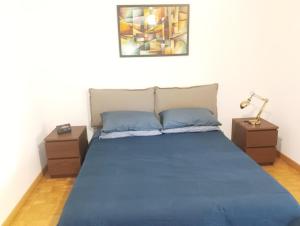 ein Schlafzimmer mit einem blauen Bett und zwei Nachttischen in der Unterkunft Sanremo Apartment in Sanremo