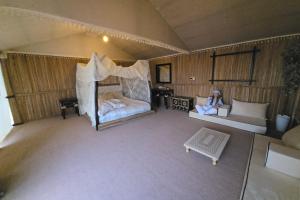 Margham的住宿－Margham Desert Safari Camp，坐在房间里床边的女人