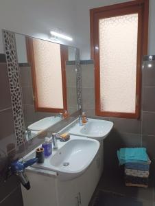 ein Badezimmer mit zwei Waschbecken und einem großen Spiegel in der Unterkunft Sanremo Apartment in Sanremo