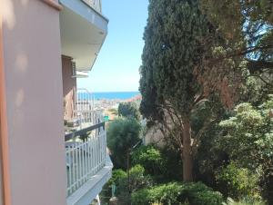 einen Blick vom Balkon eines Gebäudes mit einem Baum in der Unterkunft Sanremo Apartment in Sanremo