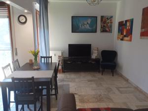 ein Wohnzimmer mit einem Tisch und einem TV in der Unterkunft Sanremo Apartment in Sanremo