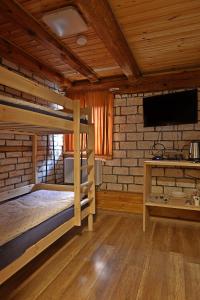 a room with two bunk beds and a flat screen tv at Agroturystyka Ranczo Gościszów in Nowogrodziec