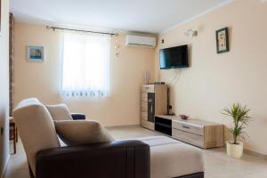 a living room with a couch and a tv at In der Nähe des Meeres, schöne und moderne Wohnung in Porat