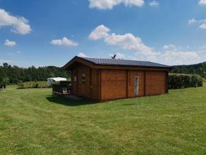 ein kleines Gebäude in der Mitte eines Feldes in der Unterkunft Domek the luxe in Šluknov