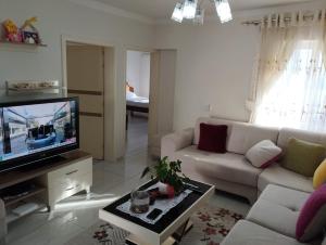 a living room with a couch and a tv at RONDO Guesthouse in Gjirokastër